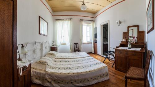 a bedroom with a large bed and a wooden floor at Nostos Guesthouse in Kythira