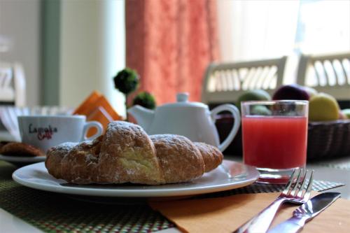 a plate of pastries on a table with a glass of juice at Hotel Veliera in Durrës