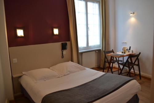 Un pat sau paturi într-o cameră la Hôtel La Porte Saint Pierre-Logis Hôtel Intra Muros