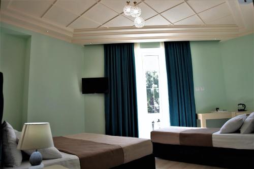 a bedroom with two beds and a window at Hotel Veliera in Durrës
