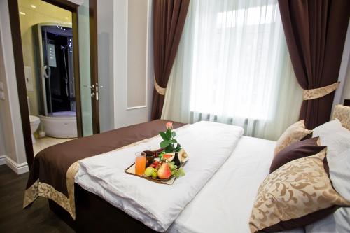 a tray of fruit on a bed in a hotel room at Boutique Hotel Leningrad in Saint Petersburg