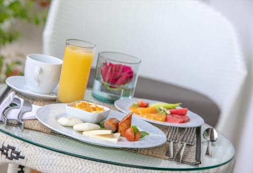 a table with two plates of food and a glass of orange juice at Hotel Noi 1860 Cartagena in Cartagena de Indias
