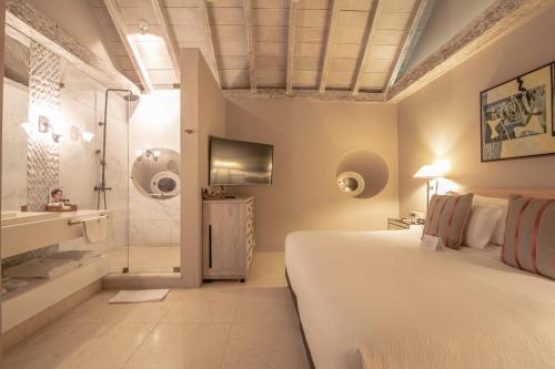 a bedroom with a bed and a bathroom with a shower at Hotel Casa Noi in Cartagena de Indias
