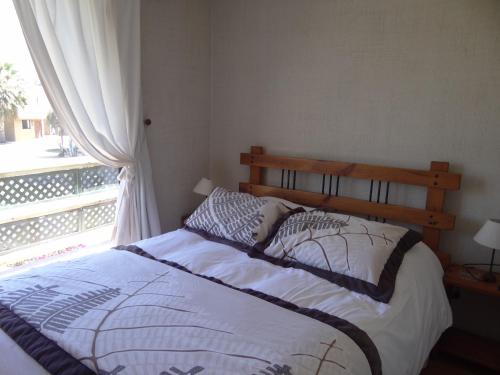 a bed sitting in a bedroom with a window at Apart Hotel Gran Pacifico in La Serena