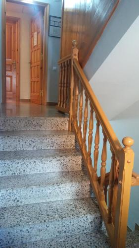 a stairway with a wooden railing and a wooden door at Hostal Casa Palmira in Espot