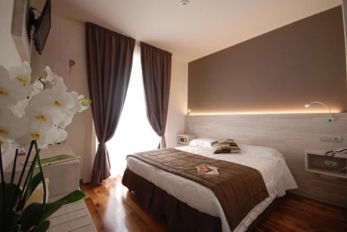 a bedroom with a bed and a large window at Hotel Giardino in Bibbiena