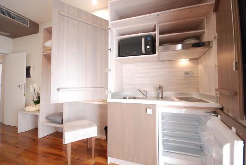 a small kitchen with white cabinets and a sink at Hotel Giardino in Bibbiena