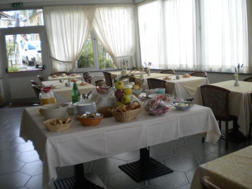a table with baskets of food on it in a restaurant at Hotel Villa Amelia in Alassio
