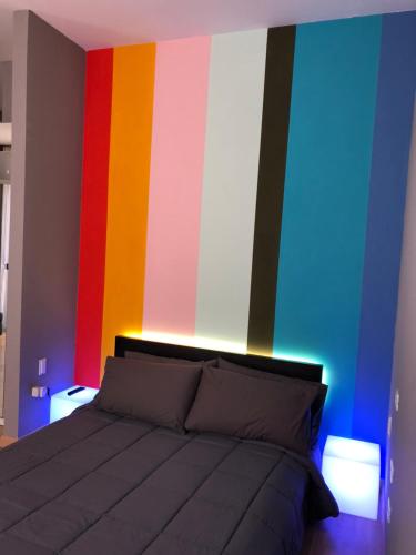 a bedroom with a bed with a colorful wall at Smart House Bologna Centro in Bologna