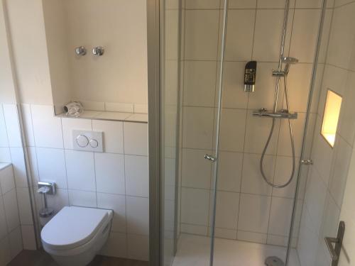 uma casa de banho com um chuveiro e um WC. em Hosser's Hotel Restaurant em Idar-Oberstein