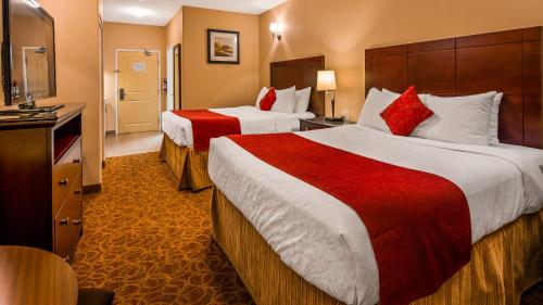 a hotel room with two beds and a television at Best Western Williams Lake in Williams Lake