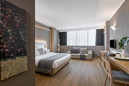 a hotel room with a bed and a desk at Porto Palace Hotel Thessaloniki in Thessaloniki