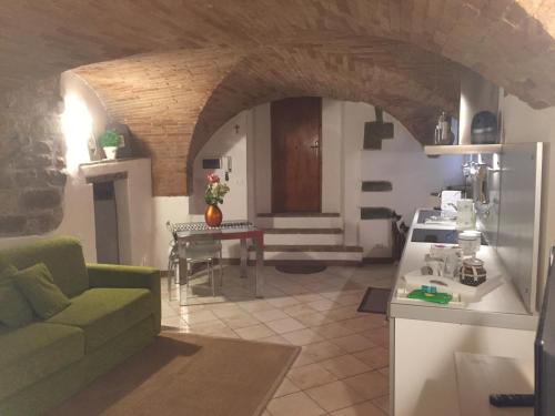 a kitchen and a living room with a couch and a table at Appartamento Via Alessi in Perugia