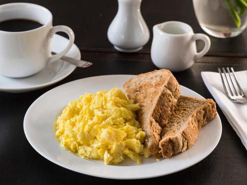 a plate of eggs and toast and a cup of coffee at HTL City Baires in Buenos Aires