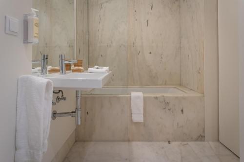 a bathroom with a sink and a bath tub at AC-Armazéns Cogumbreiro in Ponta Delgada
