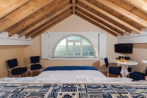 a bedroom with a large bed and a window at Chalet O Amorzinho Sintra Praia in Sintra