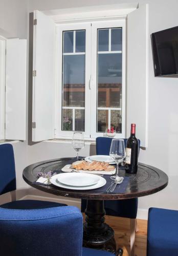 a table with a plate of food and wine glasses at Chalet O Amorzinho Sintra Praia in Sintra