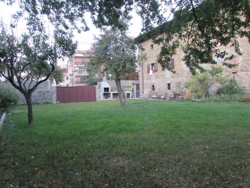a green yard with two trees in front of a building at Txantxorena in Zubiri