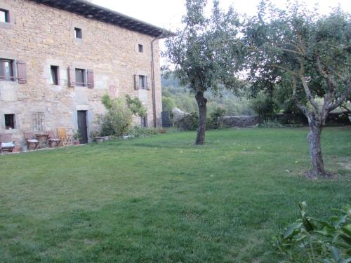two trees in a yard next to a building at Txantxorena in Zubiri