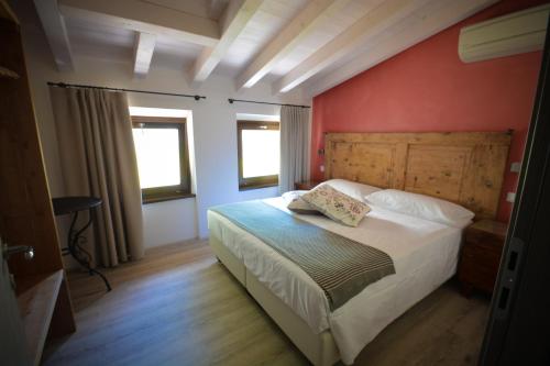 a bedroom with a bed and a red wall at Cascina Varini in Gargnano