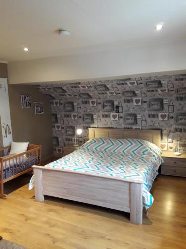 a bedroom with a bed and a wall with pictures at Le chalet d Egide in Waimes