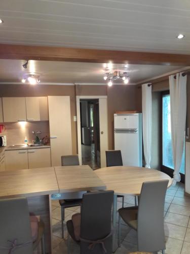 una cucina e una sala da pranzo con due tavoli e sedie di Le chalet d Egide a Waimes
