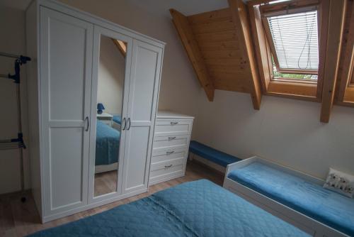 a bedroom with a bed and a dresser and a mirror at Ferienwohnung am großen Stein in Leutersdorf