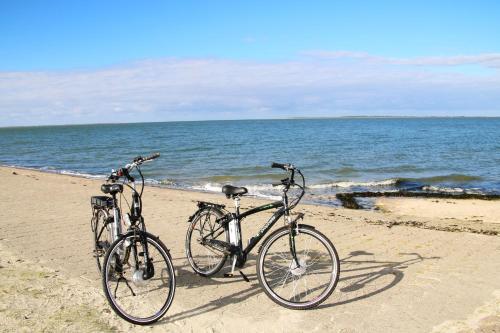 two bikes parked on a beach near the ocean at FeWo Schwarz in Dornumersiel