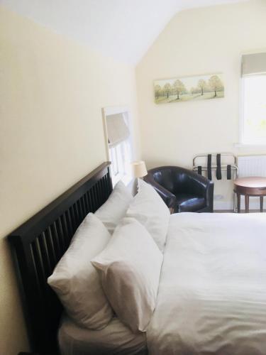 a bed with white pillows on it in a room at Elmdon Lodge in Birmingham