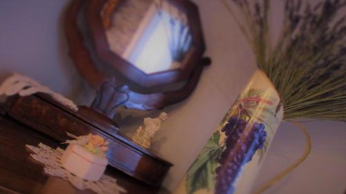 a mirror on a wall next to a table with a vase at Le Bricolle in Viggiù