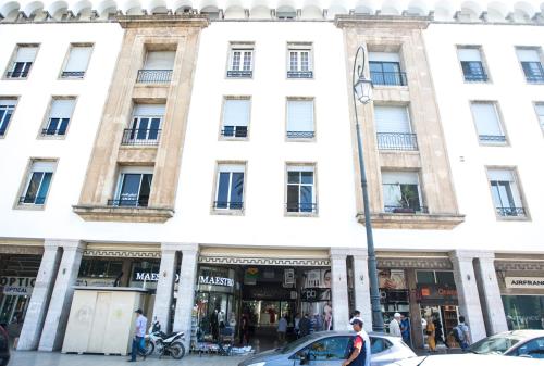 a large white building with cars parked in front of it at Junior Suite Balima I B43 in Rabat