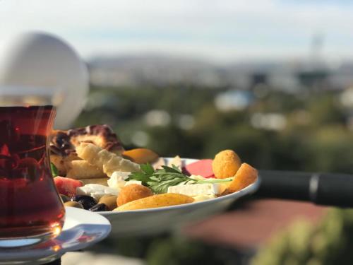 a plate of food next to a glass of tea at Bugday Hotel in Ankara