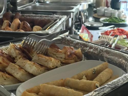 a buffet with a plate of food with a fork at Bugday Hotel in Ankara
