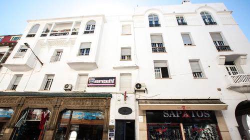 a large white building with a store in front of it at Appartements Rabat Balima Harcourt in Rabat