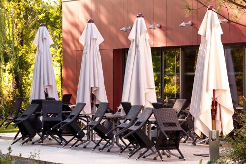 a group of umbrellas and chairs in front of a building at Kyriad Nantes Sud - Bouaye Aéroport in Bouaye