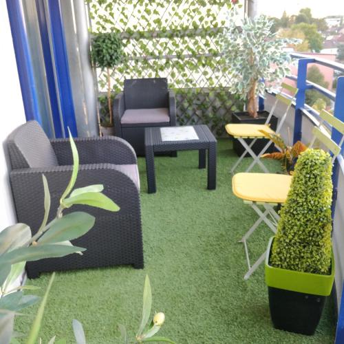 a room with chairs and plants on a balcony at Les Clés du Bonheur by Beds4Wanderlust, 47m2 avec Terrasse privative & Parking-RER B TGV 10min-Orly 20min in Massy