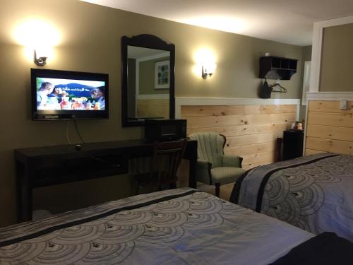a hotel room with a bed and a tv on the wall at Greenside Motel in Saint Andrews