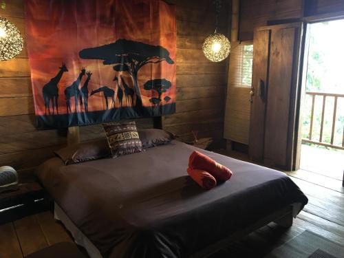 a bedroom with a bed with a painting on the wall at Monte Mágico in Támesis