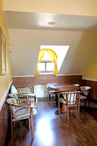 a dining room with a table and chairs and a window at Hotel Lavica in Samobor