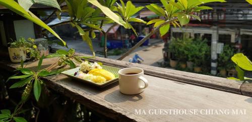 a plate of food and a cup of coffee on a table at Ma Guesthouse Chiang Mai in Chiang Mai