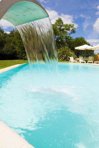 a water fountain in the middle of a swimming pool at Kyriad Nantes Sud - Bouaye Aéroport in Bouaye