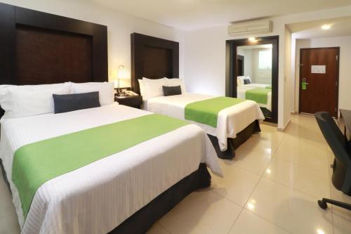 A bed or beds in a room at Wyndham Garden Guadalajara Acueducto