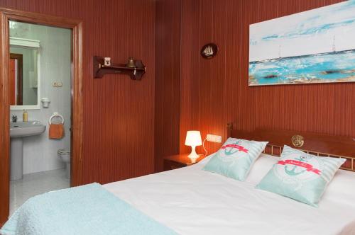 a bedroom with a bed and a bathroom with a sink at Apartamento El Parque con Vistas al Mar in Almería