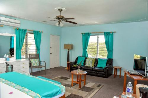 a blue room with a bed and a couch at Beyond Sunset Resort & Villas in Treasure Beach