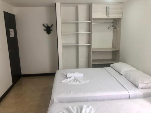 a bedroom with a white bed and a closet at Apartamentos Martinez in San Andrés