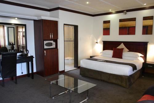 a hotel room with a bed and a desk at City Stay in Maseru