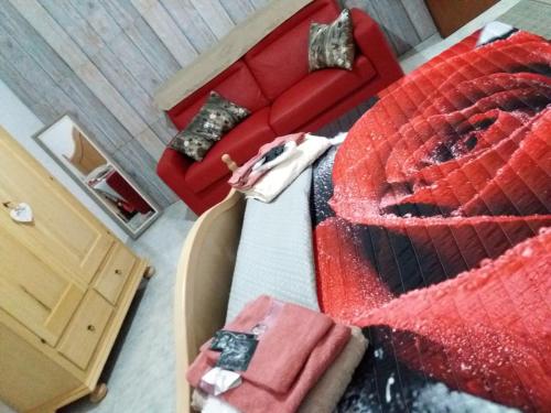 a bedroom with a red bed and a red couch at Locanda 130 in Fonni