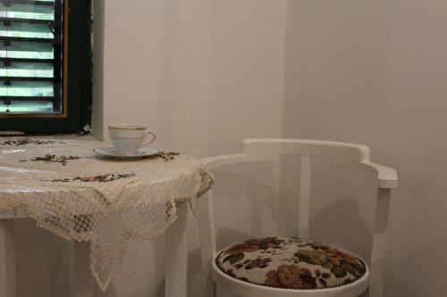 a table and a chair with a table and a cup at Patrícia Pihenőház in Alsónána