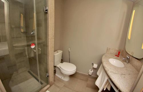 a bathroom with a shower and a toilet and a sink at ibis Natal in Natal
