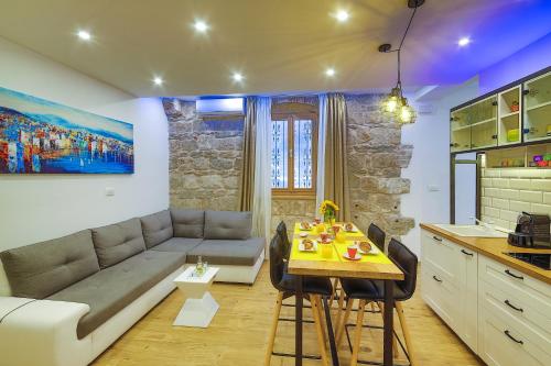 ein Wohnzimmer mit einem Sofa und einem Tisch in der Unterkunft Bacvice apartment Slavija in Split
